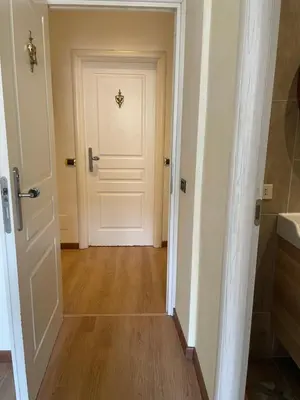 a hallway with a white door and a wooden floor at Le Petit Real in Rome