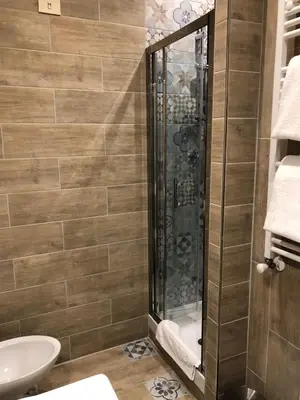 a bathroom with a shower with a toilet and a sink at Le Petit Real in Rome