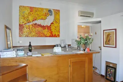 a reception desk with a painting on the wall at Le Petit Real in Rome
