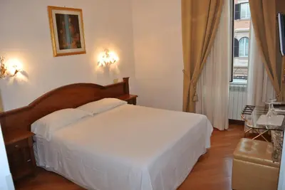 a bedroom with a large white bed and a window at Le Petit Real in Rome