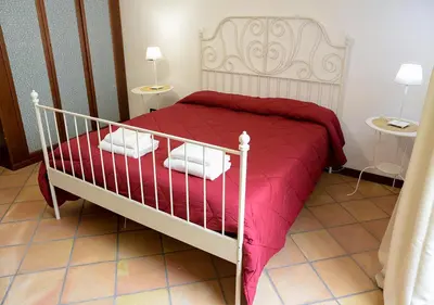 a bedroom with a bed with a red blanket at Colosseum Comfortable Apartment in Rome