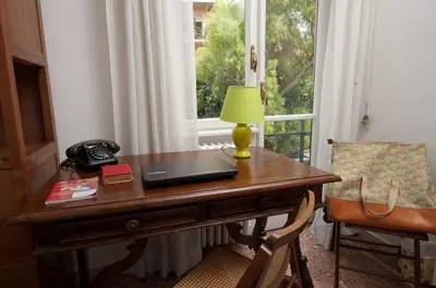 a desk with a laptop computer on it next to a window at 2 Passi Da in Rome
