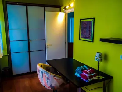 a green room with a table and a chair at 4321 B&B Stazione Trastevere in Rome