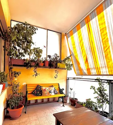a bench in a room with plants and windows at 4321 B&B Stazione Trastevere in Rome