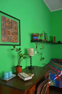 a green bedroom with a desk with a lamp and a bed at 4321 B&B Stazione Trastevere in Rome