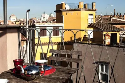 a balcony with a table and a chair on a roof at Archdesign Studio in Rome