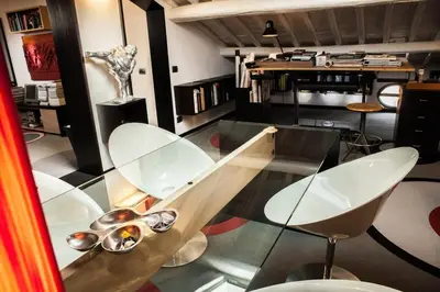 a glass table with white chairs and a vase at Archdesign Studio in Rome