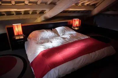 a red bed with two lights on top of it at Archdesign Studio in Rome
