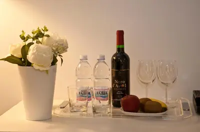 a bottle of wine and a plate of fruit and glasses at B&B La finestra sul Colosseo in Rome