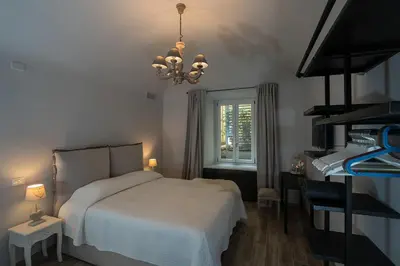 a bedroom with a bed and a window and a chandelier at Laura Family Apartments in Rome