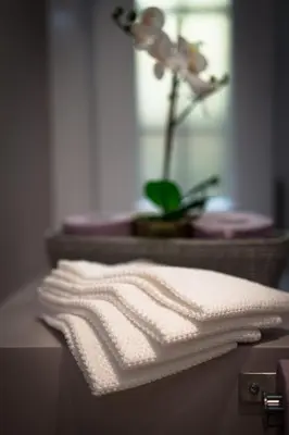 a stack of white towels on a counter with a flower at Laura Family Apartments in Rome