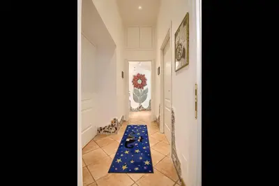 a hallway with a blue rug on the floor at Gli Artisti Apartments Rome in Rome