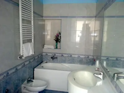 a bathroom with a tub and a sink and a toilet at Hotel Louisiana in Rome