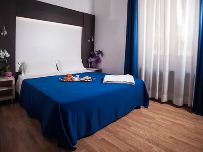 a bedroom with a blue bed with a tray of food on it at Hotel Louisiana in Rome