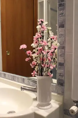 a vase of pink flowers sitting on a bathroom sink at Hotel Louisiana in Rome