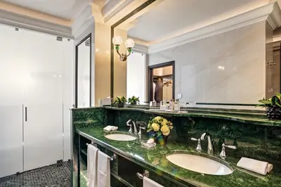 a bathroom with two sinks and a large mirror at Hassler Roma in Rome