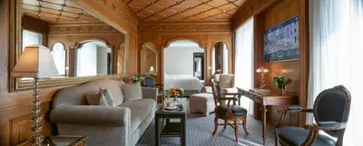 a living room with a couch and a desk and a bedroom at Hassler Roma in Rome