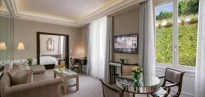 a hotel room with a living room with a bed at Hassler Roma in Rome