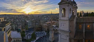 a view of a city at sunset with a clock tower at Hassler Roma in Rome