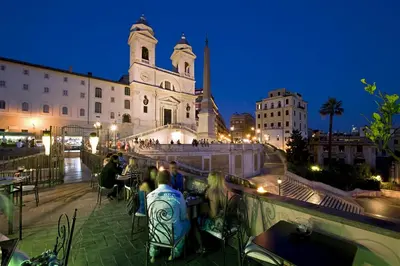 a group of people sitting at tables in front of a church at Il Palazzetto in Rome