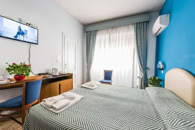 a hotel room with a bed and a desk and a window at Ai Musei Vaticani BB in Rome