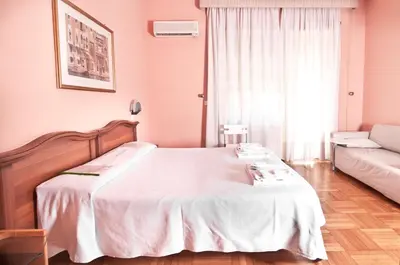 a bedroom with a large white bed and a couch at Ai Musei Vaticani BB in Rome