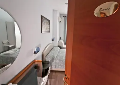 a room with two beds and a wooden door at Ai Musei Vaticani BB in Rome