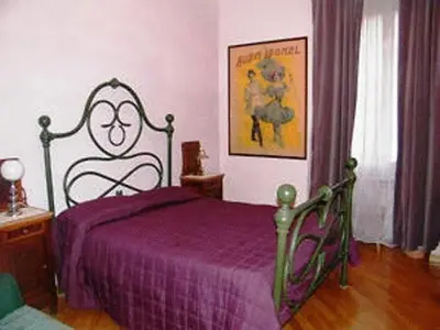 a bedroom with a bed with a purple blanket at Vacanze Romane in Rome