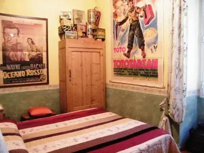 a bedroom with a bed and posters on the wall at Vacanze Romane in Rome