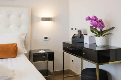 a bedroom with a bed and a desk with purple flowers at Zaccardi Roof Garden in Rome