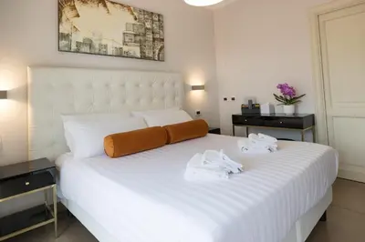 a bedroom with a large white bed with towels on it at Zaccardi Roof Garden in Rome