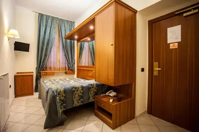 a small bedroom with a bed and a cabinet at Hotel Domus Praetoria in Rome