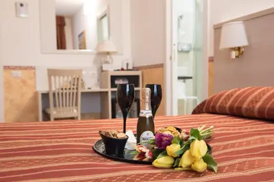 a tray with a bottle of wine and flowers on a bed at Domus Giulia in Rome