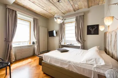 a bedroom with a large bed and two windows at Rooms Roma - Monti in Rome
