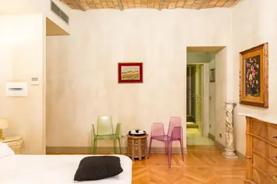 a bedroom with colorful chairs and a bed at Rooms Roma - Monti in Rome