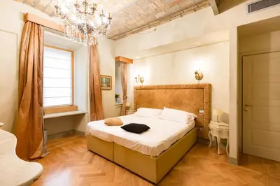a bedroom with a bed and a chandelier at Rooms Roma - Monti in Rome