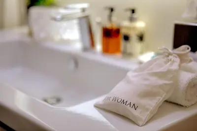 a white bathroom sink with a bag of towels on it at Singer Palace Hotel Roma in Rome