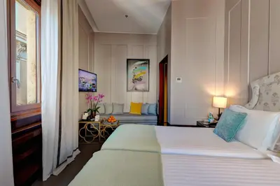 a bedroom with a large bed and a couch at Singer Palace Hotel Roma in Rome