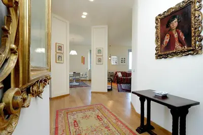 a living room with a table and a painting on the wall at Saint Peter's Bright Apartment | Romeloft in Rome