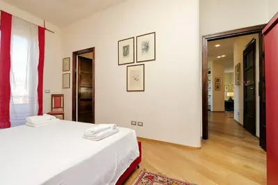a white room with a bed and a hallway at Saint Peter's Bright Apartment | Romeloft in Rome