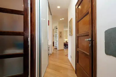 a hallway with a wooden door and a room at Saint Peter's Bright Apartment | Romeloft in Rome