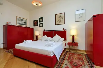 a bedroom with a large bed with red furniture at Saint Peter's Bright Apartment | Romeloft in Rome
