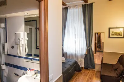 a hotel room with a couch and a mirror at San Peter Rome B&B in Rome