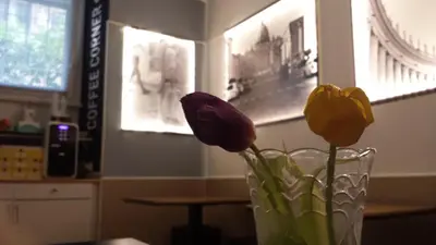 a glass vase with flowers in it on a table at San Peter Rome B&B in Rome