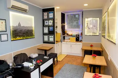 a room with tables and chairs and a kitchen at San Peter Rome B&B in Rome