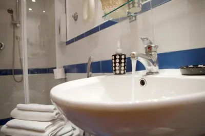 a bathroom with a sink and a shower with towels at San Peter Rome B&B in Rome