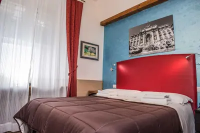 a bedroom with a large bed with a red headboard at San Peter Rome B&B in Rome