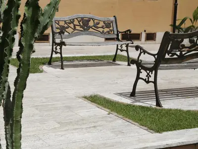 two park benches sitting next to a cactus at Guest House Trastevere in Rome