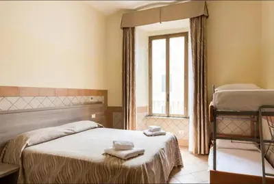 a bedroom with two beds and a window at Alex Romano in Rome