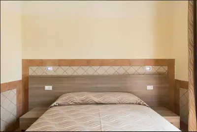a bed with a wooden headboard in a bedroom at Alex Romano in Rome